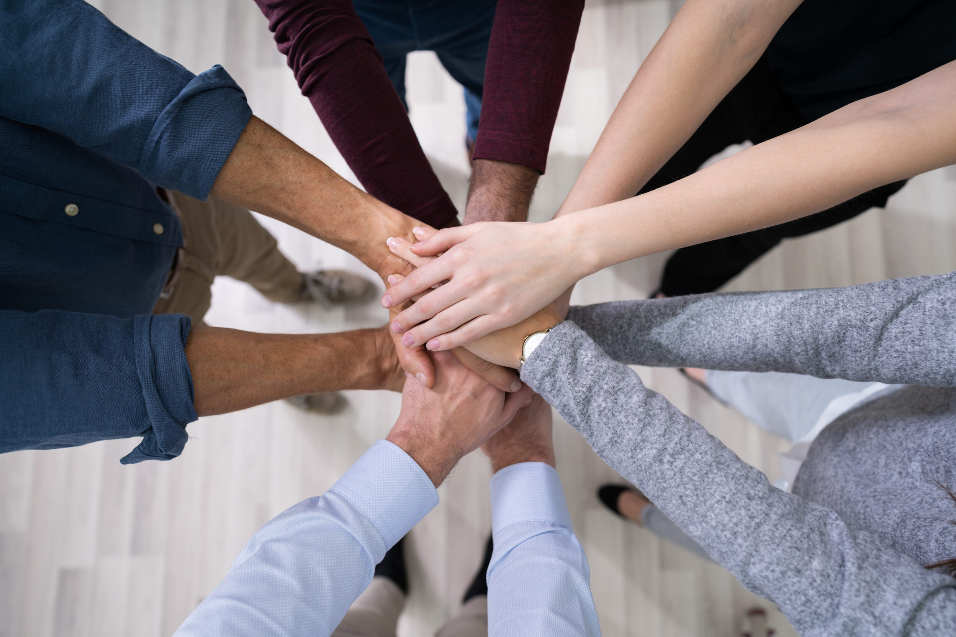 Close-up Of Many Hands Lying On Top Of Each Other
